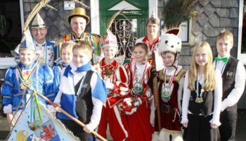 Prinz Theo, Jungfrau Emily und Bauer David vom Voiswinkeler Kinderdreigestirn sowie Prinz Jonas und Prinzessin Nina, Kinderprinzenpaar aus Leichlingen beim traditionellen Hähnchen-Essen mit Rainer Deppe.