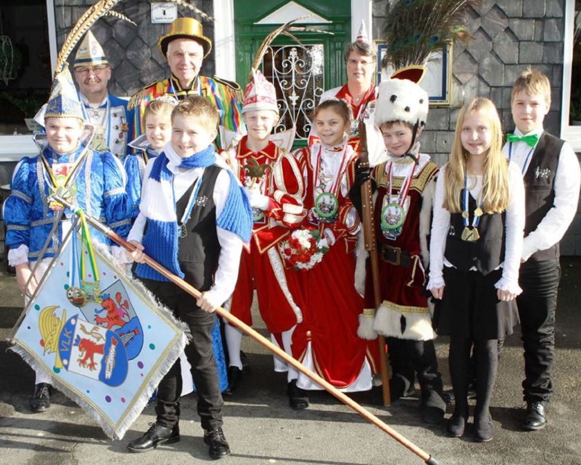 Prinz Theo, Jungfrau Emily und Bauer David vom Voiswinkeler Kinderdreigestirn sowie Prinz Jonas und Prinzessin Nina, Kinderprinzenpaar aus Leichlingen beim traditionellen Hähnchen-Essen mit Rainer Deppe.