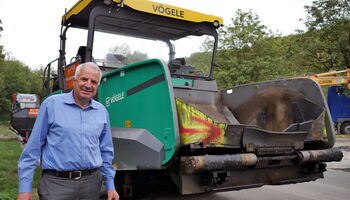 Rainer Deppe neben einer Straßenbaumaschine