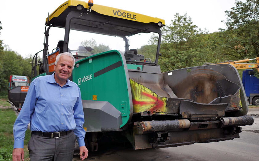 Rainer Deppe neben einer Straßenbaumaschine